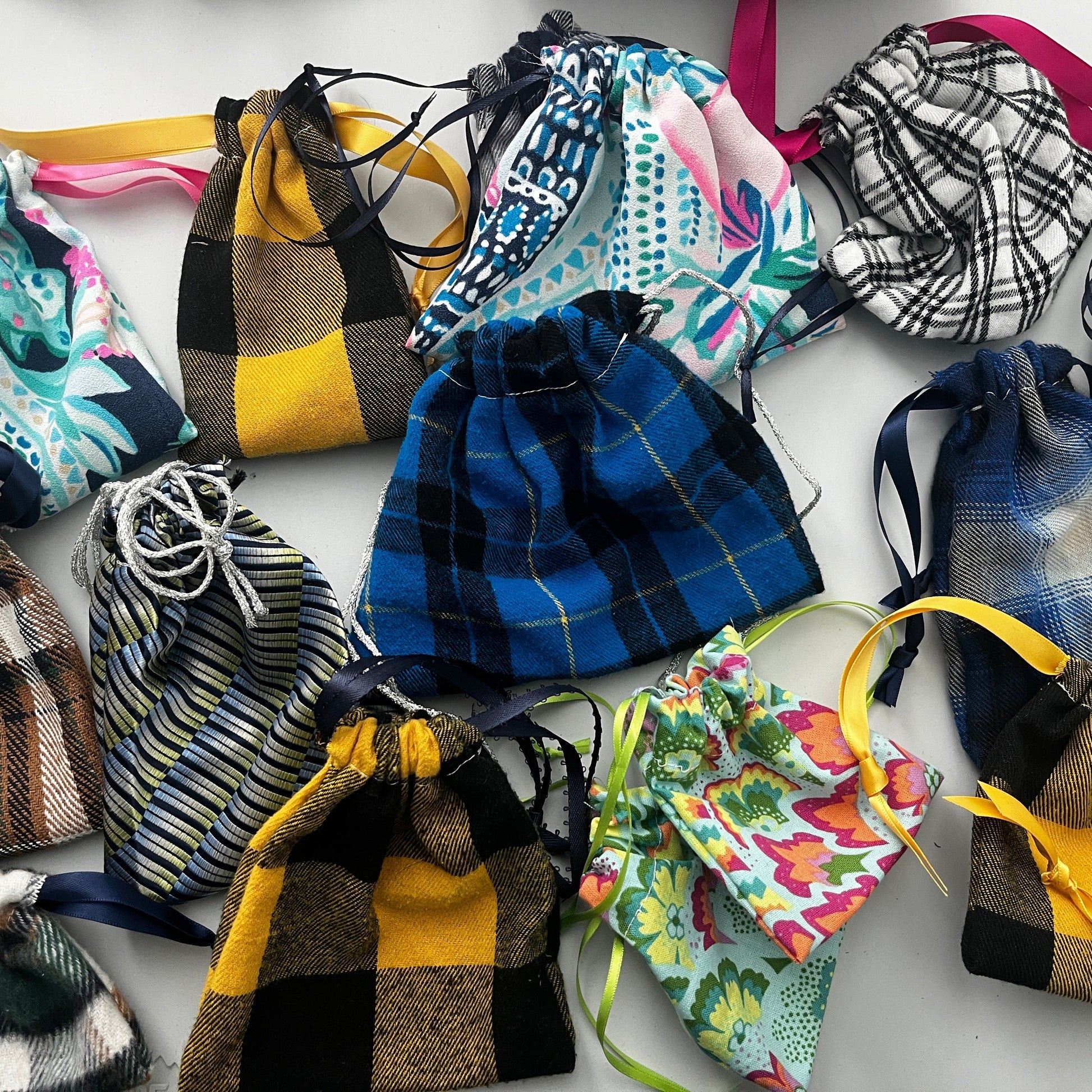 Collection of colorful drawstring bags on a white background